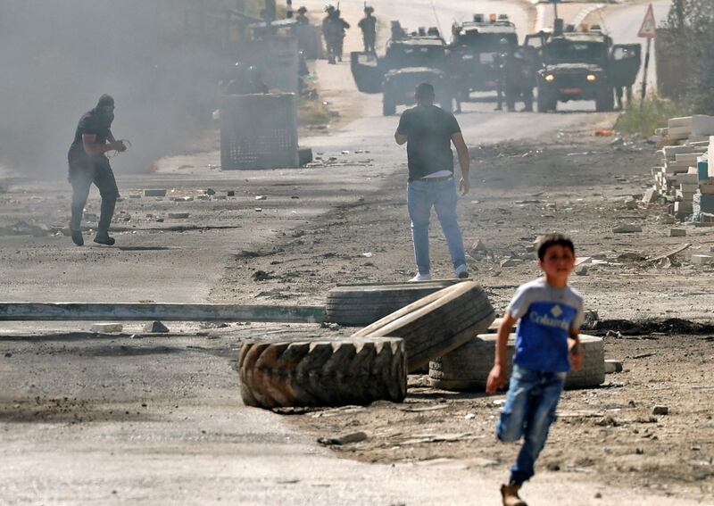 A child runs away from a confrontation between Palestinian protesters and Israeli security forces, at Beita village in the occupied West Bank. AFP