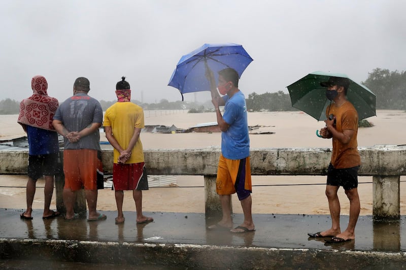 Residents look at a swollen river as floods continue to rise in Marikina. AP Photo