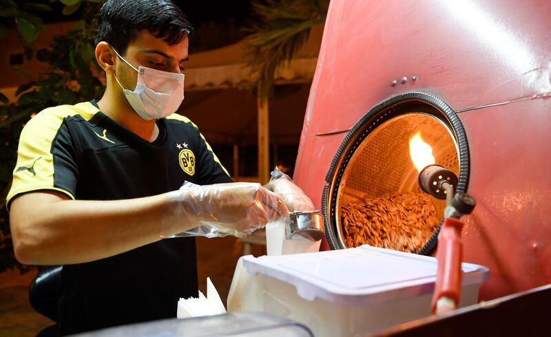 A vendor sells roasted sunflower seeds while wearing a protective mask during the Ramadan in Bilad al Qadeem suburb of the Bahraini capital Manama. AFP