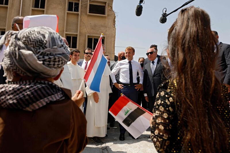 French President Emmanuel Macron is welcomed upon his arrival at the Our Lady of the Hour Church in Iraq's second city of Mosul. AFP