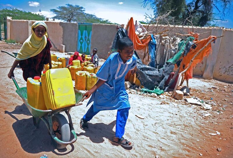 Refugee children push wheelbarrows loaded with Jerry cans full of drinking water from a water pump in Hargeisa, the capital of Somaliland, on May 16, 2015. Mohammed Abdiwahab/AFP Photo 