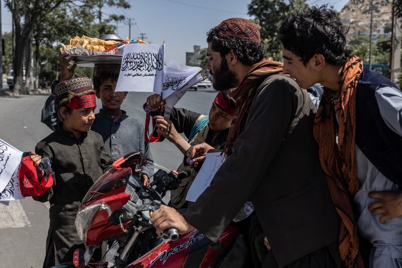 Street-working children are selling Taliban flags and bandanas in Kabul.