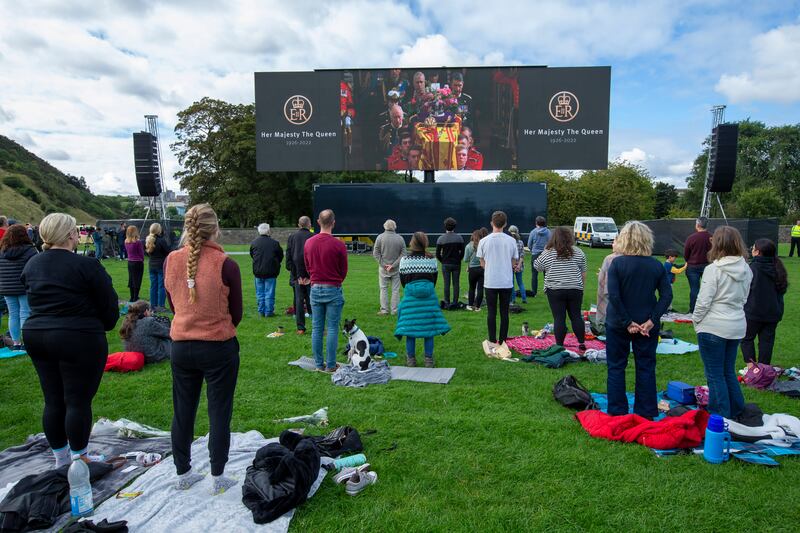 People stand as they watch the funeral in Holyrood Park, Edinburgh. Getty Images