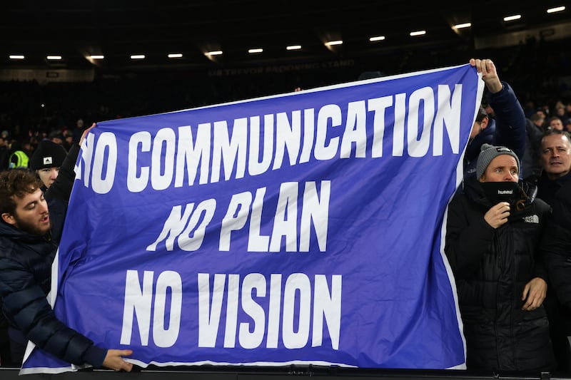 Everton fans hold banners aimed at the club's owners. Getty