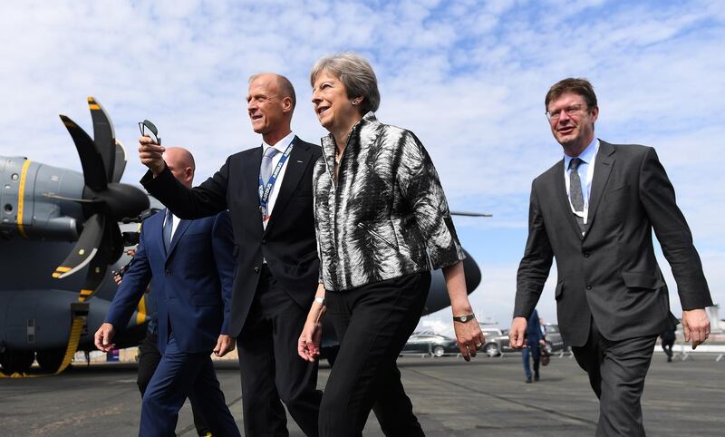 epa06892752 British Prime Minister Theresa May (C) is accompanied by Airbus CEO Tom Enders (2-L) and British Secretary of State for Business, Energy and Industrial Strategy Greg Clark (R) as they walk around at the Farnborough International Airshow (FIA2018), in Farnborough, Britain, 16 July 2018. The international aircraft and aviation fair runs from 16 to 22 July 2018.  EPA/ANDY RAIN
