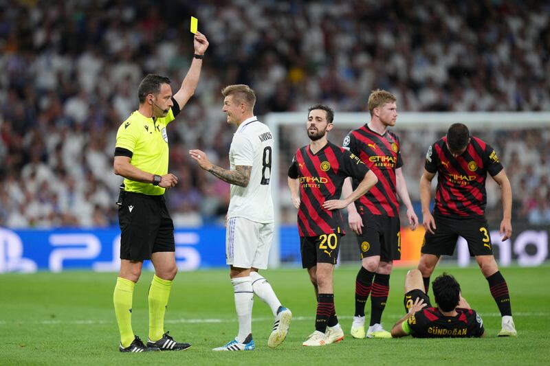 Referee Artur Dias Soares shows a yellow card to Toni Kroos of Real Madrid for a foul on Manchester City's Ilkay Gundogan. Getty