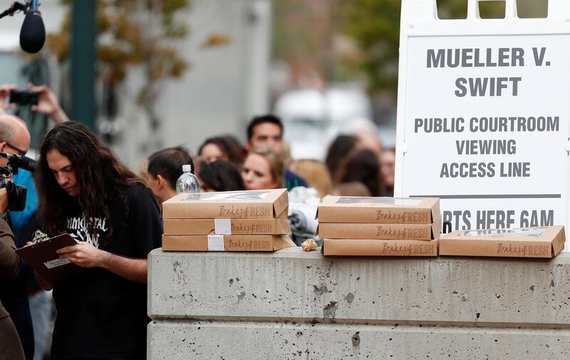 Anthony Reyther, a member of the public waiting to attend the morning session of the pop singer Taylor Swift, signs in with court officials before going into the federal courthouse to view the civil trial for the pop singer, Friday, Aug. 11, 2017, in Denver. Radio station DJ David Mueller sued Swift after her team reported she was groped by Mueller to his bosses at a country music station. He is seeking up to $3 million, saying the allegation cost him his job and reputation. Swift countersued Mueller, claiming sexual assault. She is seeking a symbolic $1.   (AP Photo/David Zalubowski)