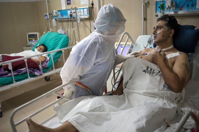 Dr Rosa Lopez comforts her colleague Victor Cuba, an emergency room nurse infected with Covid-19, inside the Guillermo Almenara hospital in Lima, Peru. AP Photo