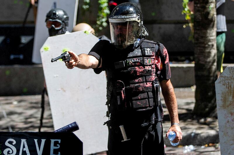 Alan Swinney points a gun during clashes between groups like Proud Boys and Patriot Prayer, and protesters against police brutality and racial injustice in Portland, Oregon, on August 22, 2020. Reuters