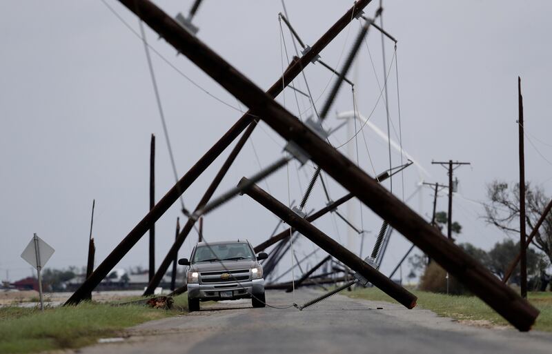 A driver works his way through a maze of fallen utility poles damaged in the wake of Hurricane Harvey in Taft, Texas. Eric Gay / AP Photo