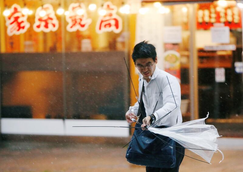 A man using an umbrella struggles against a heavy rain and wind as Typhoon Jongdari approaches Japan's mainland in Tokyo, Japan. Issei Kato/Reuters