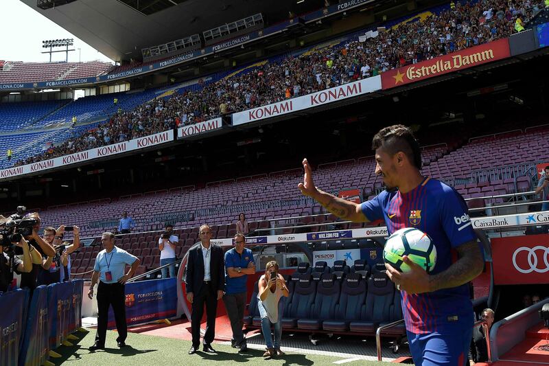 Barcelona's new Brazilian football player Paulinho waves as he enters the pitch at Camp Nou. Lluis Gene / AFP