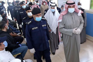 Kuwaiti Prime Minister Sheikh Sabah al-Khaled al-Sabah (R), wearing a protective mask amid the coronavirus pandemic, arrives to cast his votes at a polling station in Kuwait City during parliamentary elections on December 5, 2020. Kuwait's general elections have started under the shadow of Covid-19, with facilities laid on for citizens infected with the disease to vote in special polling stations. Unlike other oil-rich Gulf states, Kuwait has a lively political life with a parliament elected for four-year terms that enjoys wide legislative powers. / AFP / YASSER AL-ZAYYAT