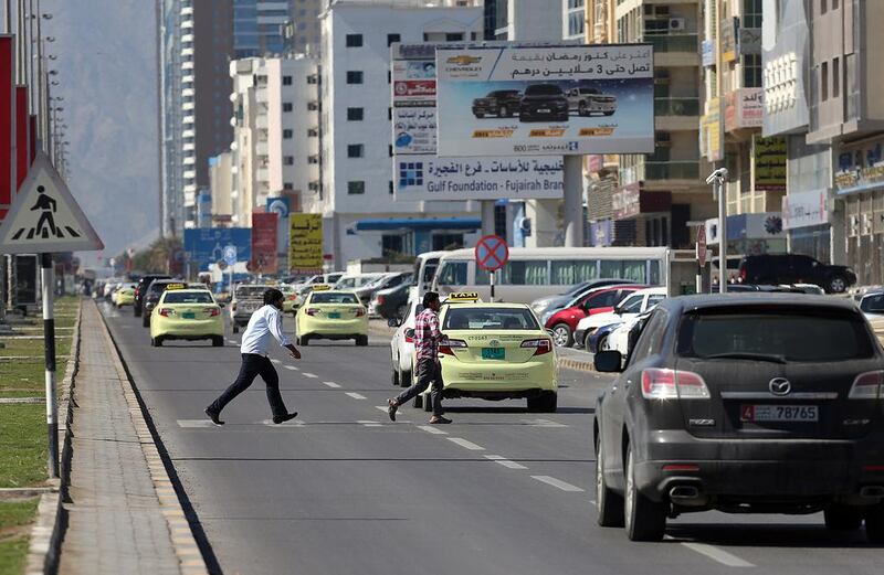 Men cross the road in a designated area in Fujairah. Pedestrians have been asked to avoid undesignated areas following the death of a man while crossing the road in neighbouring Ras Al Khaimah on Tuesday. Satish Kumar / The National