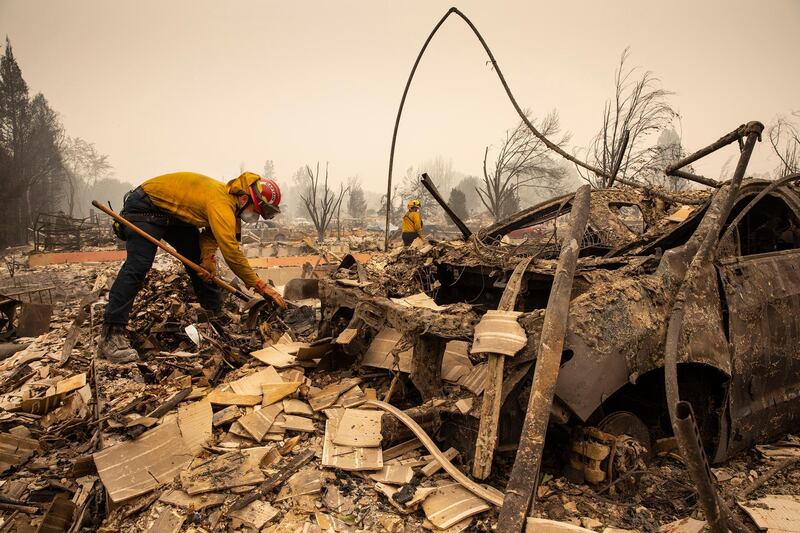 Firefighter Capt Aaron Bustard puts out smouldering fires in a burned neighbourhood in Talent, Oregon. AP Photo