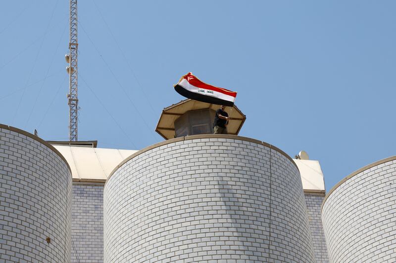 A supporter of Mr Al Sadr waves a flag during the protest at the parliament building. Reuters