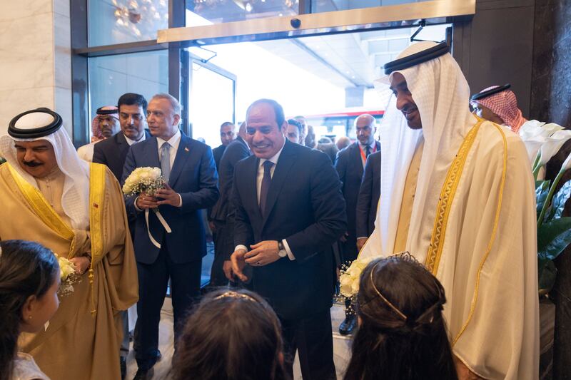 Sheikh Mohamed, King Hamad and Mr Al Kadhimi receive flowers as Mr El Sisi watches on.