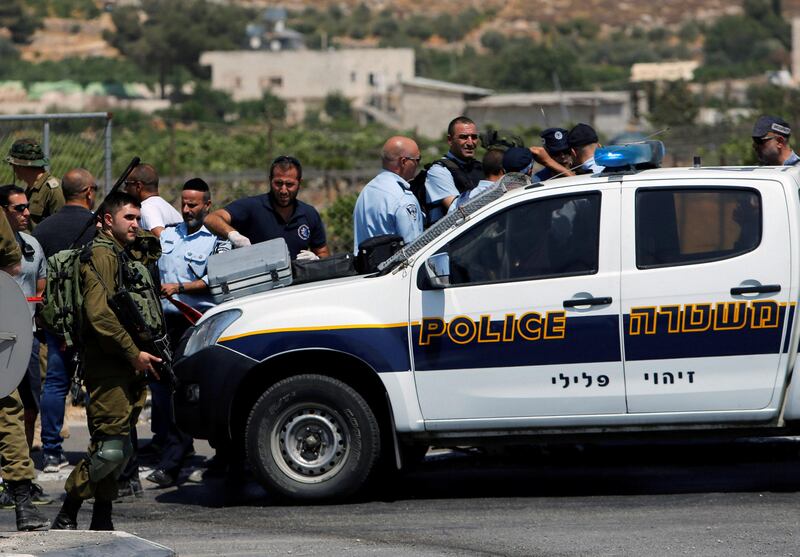 Israeli forces gather at the scene of a Palestinian car-ramming attack at the entrance of Beit Einun village, near the West Bank city of Hebron July 18, 2017. REUTERS/Mussa Qawasma