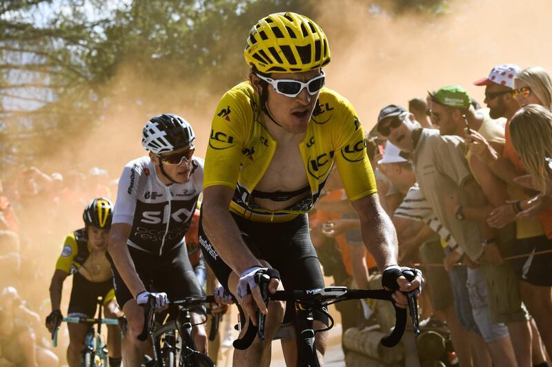 TOPSHOT - Great Britain's Geraint Thomas (R), wearing the overall leader's yellow jersey, and Great Britain's Christopher Froome (C) rides through the so-called "Dutch Corner" in the ascent to l'Alpe d'Huez during the twelfth stage of the 105th edition of the Tour de France cycling race, between Bourg-Saint-Maurice - Les Arcs and l'Alpe d'Huez, on July 19, 2018.  / AFP / Jeff PACHOUD
