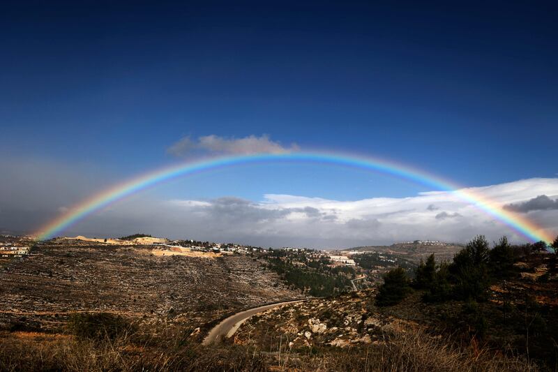 This picture taken on December 20, 2021 shows a view of a rainbow in the sky above the Israeli settlement of Eli, south of Nablus in the occupied West Bank.  (Photo by JAAFAR ASHTIYEH  /  AFP)