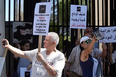 Banks customers and depositors carry placards during a protest against the monetary policies of Lebanese Central Bank governor Riad Salameh in Beirut, Lebanon. EPA