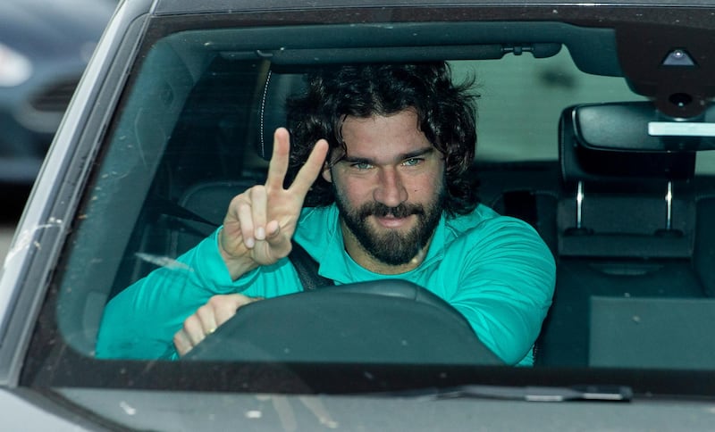 Liverpool goalkeeper Alisson Becker gives a V-sign as he arrives for a training session to the Melwood training facility in Liverpool. EPA