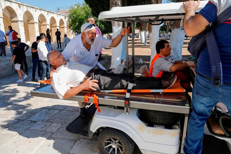 Palestinians evacuate a man at the Al Aqsa Mosque compound. AFP