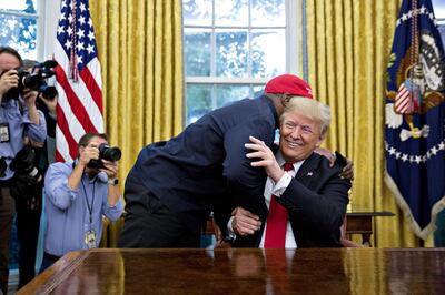 Rapper Kanye West, left, hugs U.S. President Donald Trump during a meeting in the Oval Office of the White House in Washington, D.C., U.S., on Thursday, Oct. 11, 2018. West, a recording artist and prominent Trump supporter, is at the White House to have lunch with the president and to meet with presidential son-in-law and senior adviser Jared Kushner who has spearheaded the administrations efforts overhaul the criminal justice system. Photographer: Andrew Harrer/Bloomberg