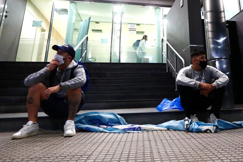 Fans of Diego Maradona wearing face masks wait outside of Clínica Olivos. Getty Images