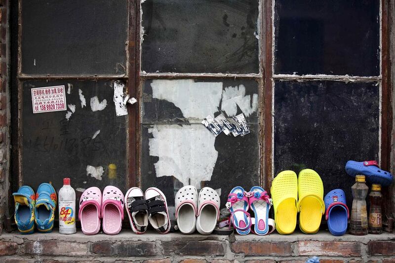 Children’s shoes rest against a window at a recycling workers’ tenement house in Dongxiaokou village. Kim Kyung-Hoon / Reuters