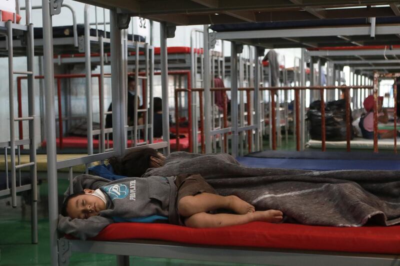 A mother and child sleep in a cot at the Kiki Romero Sports Complex, in Ciudad Juarez, Mexico, April 21. AP