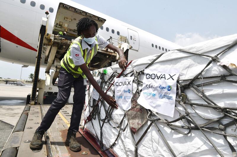 An airport worker puts Covax labels on Oxford-AstraZeneca Covid-19 vaccines being unloaded at Felix Houphouet Boigny Airport, Abidjan, Ivory Coast. The country has received 504,000 doses from Covax, which provides inoculations for poorer countries. AFP