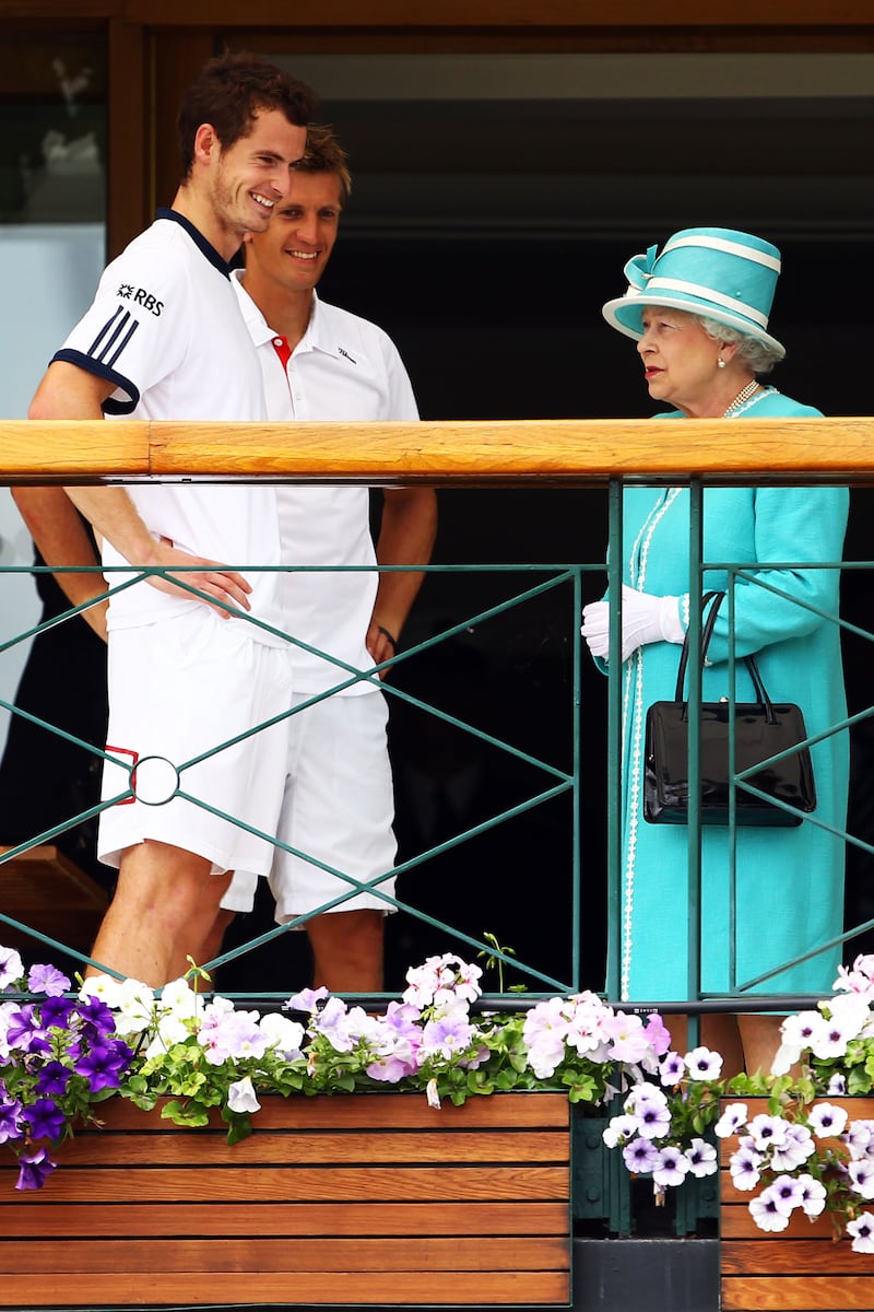 UK tennis player Andy Murray and Jarkko Nieminen of Finland meet the queen at Wimbledon. Getty