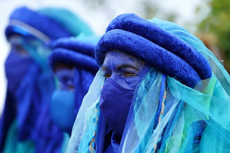 Climate activists dress in blue costumes as they demonstrate in St. Ives. AP Photo
