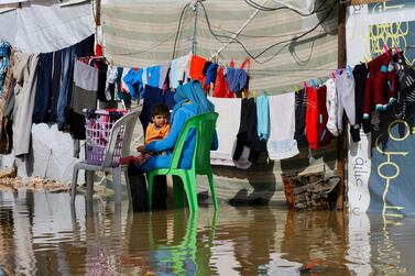A Syrian refugee hangs clothes to dry at a flooded refugee camp in the town of Bar Elias, in the Bekaa Valley, Lebanon, Thursday, Jan. 10, 2019. AP