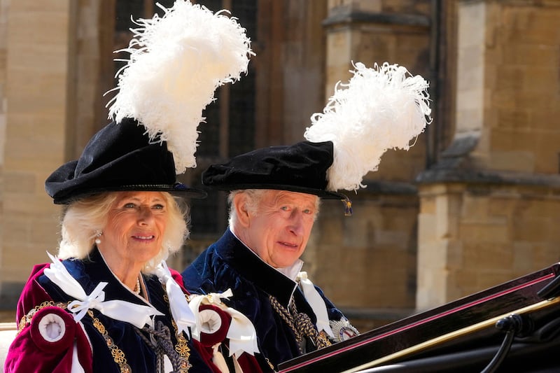 Britain's King Charles III and Britain's Queen Camilla wave as they leave by carriage after attending the Order of the Garter service, at St George's Chapel, at Windsor Castle. AFP