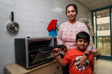 Diana Dsouza and her son Dhruv along with the conventional oven she purchased for Dh400 in July. Ms Dsouza regrets buying the oven after baking extensively and putting on 5kgs of weight during the pandemic. Photo: Antonie Robertson / The National