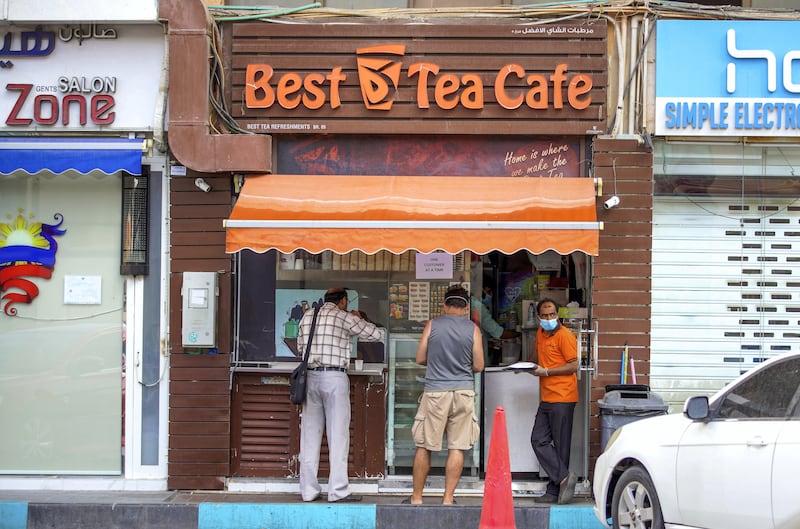 Abu Dhabi, United Arab Emirates, April 6, 2020.  An Abu Dhabi resident orders some tea in front of the Al Wahda Mall.  UAE health ministry advised residents to wear a mask when they are outside, whether they are showing symptoms of Covid-19 or not.
 Victor Besa / The National
Section:  NA
Reporter: