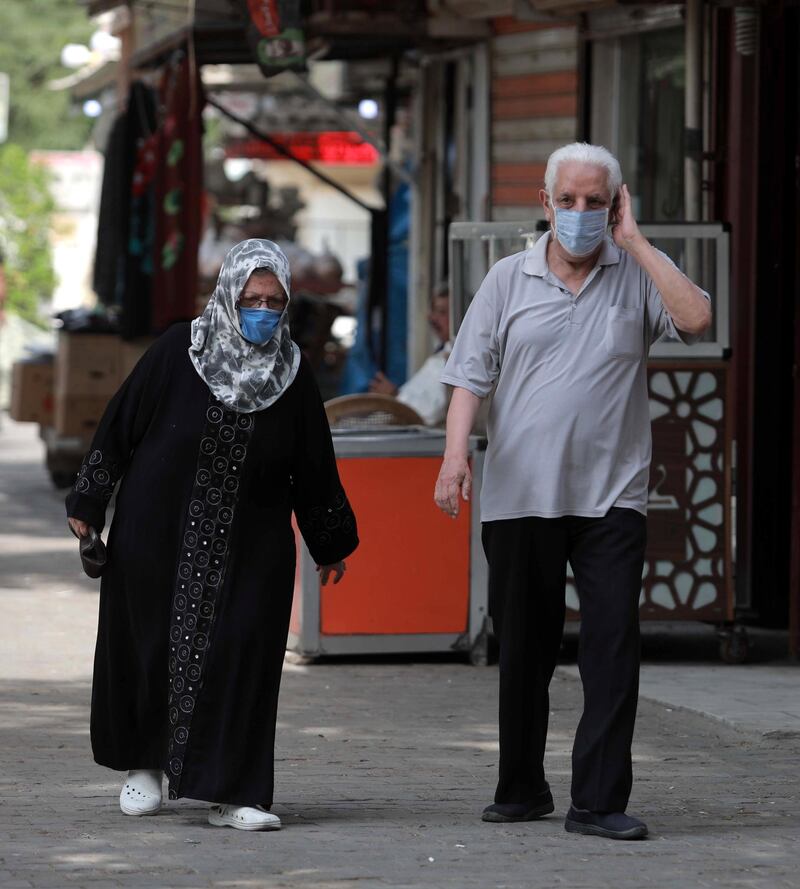 An elderly man and woman walk next to closed shops in central Baghdad, Iraq. EPA