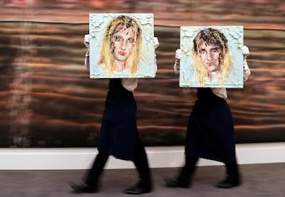 Two Sotheby's employees walk with Kaari Upson's oil on panel pictures 'For a Good Time' with the estimate value of 15,000-20,000 pound, 16,800-22,400 euro, at the Sotheby's auction house in London, Friday, Sept. 8, 2017. Over 300 works from Mario Testino's Remarkable Personal Art Collection are on display for the first time at Sotheby's in London From Sept. 8 -13. (AP Photo/Frank Augstein)