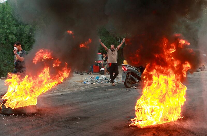 Anti-government protesters set fires and close a street during a demonstration in Baghdad, Iraq.  AP Photo