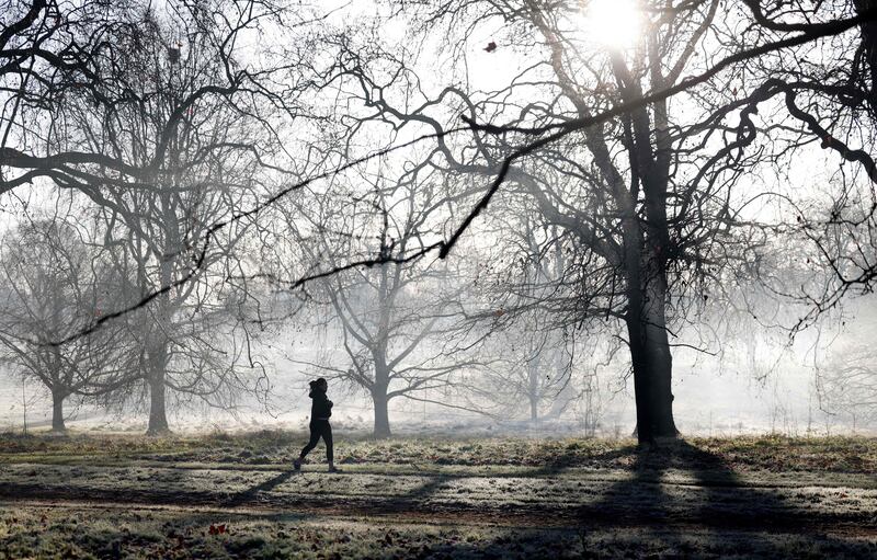 A jogger runs in a frost-covered Hyde Park in London on January 18. AFP