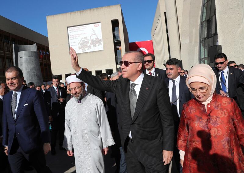 Turkish President Recep Tayyip Erdogan, centre, accompanied by his wife Emine, right, waves after attending the inauguration of a new mosque in Cologne, Germany, Saturday, Sept. 29, 2018. Erdogan has wound up a sometimes-fraught three-day official state visit to Germany with the opening of the mega mosque, belonging to the Turkish-Islamic Union for Religious Affairs. (Presidential Press Service via AP, Pool)