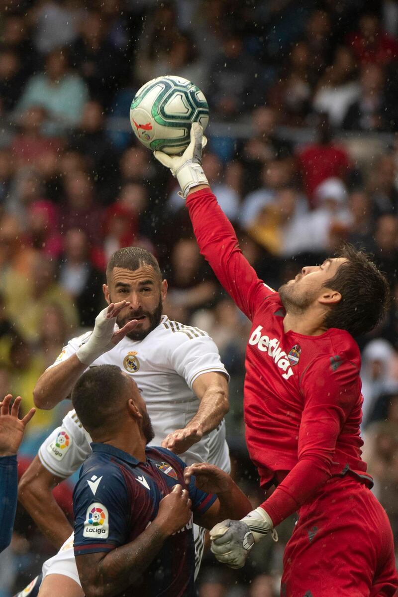 Real Madrid's French forward Karim Benzema and Levante's Spanish goalkeeper Aitor Fernandez jump for the ball. AFP
