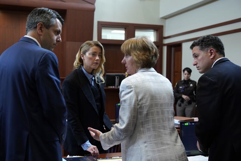 Actor Amber Heard convenes with her legal team at lunch break before taking the stand. EPA