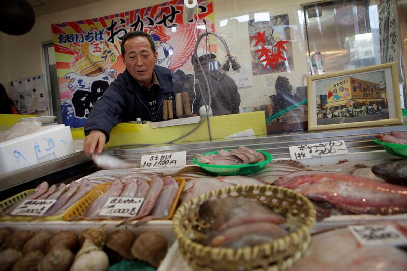 Makoto Oka, owner of fish shop, Okasei, checks fish at his shop in Onagawa in Miyagi prefecture, Japan on Feb 28, 2012. Oka's former shop was swept away by the massive tsunami hit northern Japan on March 11, 2011. 
Photo by Kuni Takahashi