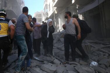 People walk on rubble after an air strike by regime forces and their allies on the Syrian town of Maaret Al Numan, Idlib province, on May 26, 2019 AFP