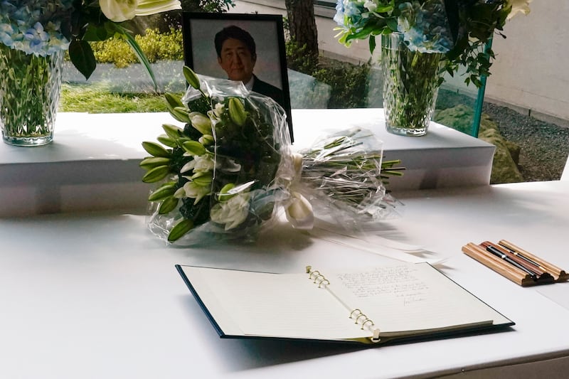 Mr Biden's bouquet of lilies sits opposite the book of condolence. AP