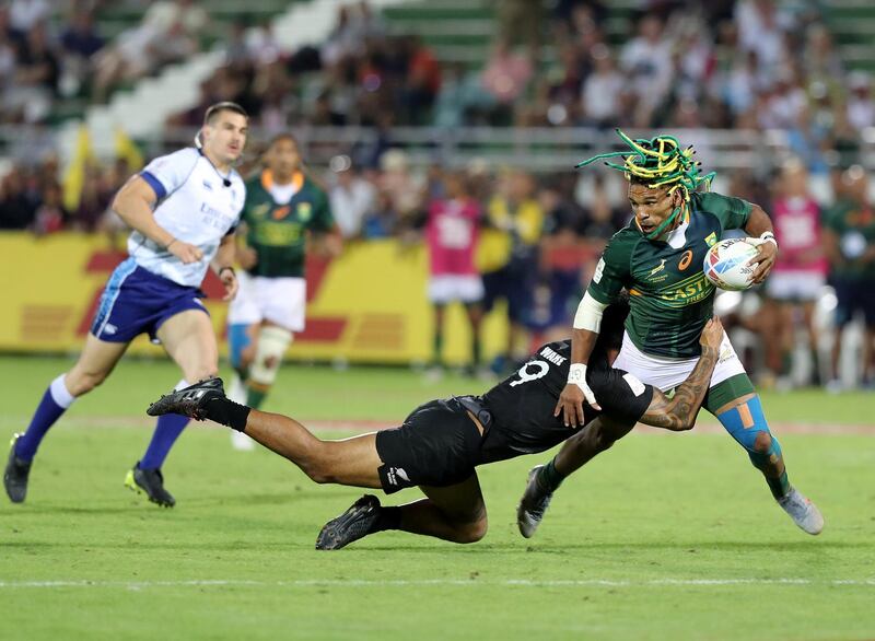 Dubai, United Arab Emirates - December 07, 2019: Rosko Specman of South Africa is tackled by Regan Ware of New Zealand during the game between New Zealand and South Africa in the mens final at the HSBC rugby sevens series 2020. Saturday, December 7th, 2019. The Sevens, Dubai. Chris Whiteoak / The National