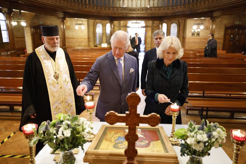 The Prince of Wales and the Duchess of Cornwall light candles during a visit to the Ukrainian Catholic Cathedral of the Holy Family, in London, on Wednesday, March 2, 2022. PA